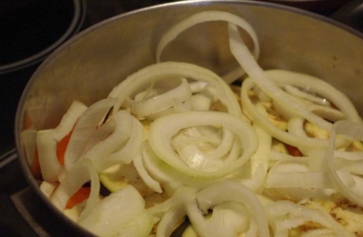 1. Этап. Гарнир к куриным котлетам: Порежьте лук колечками и также сделайте слой из половины лука.