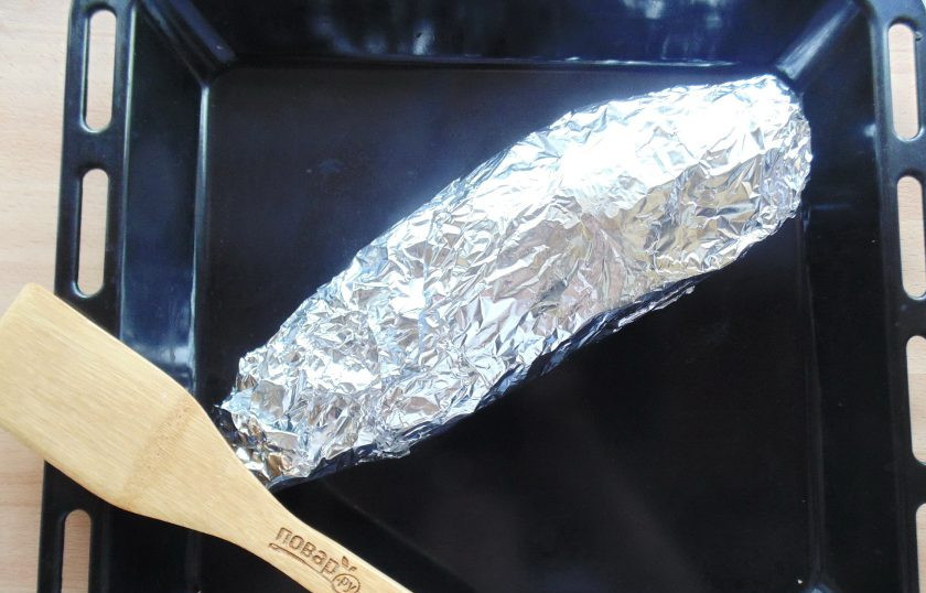1. Этап. Белый амур в фольге в духовке: Заверните рыбу с овощами в два-три слоя фольги. Выложите на противень и отправьте в духовку, разогретую до 180-185 градусов.