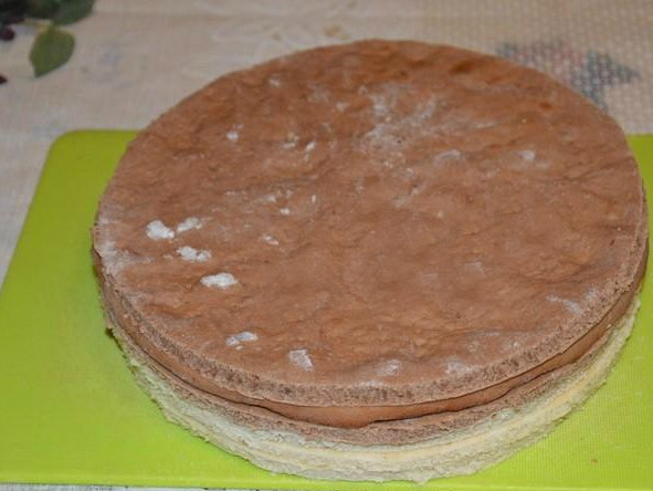 1. Этап. Детский торт с мишкой: Делим тесто обоих цветов на 3 части. Из каждого шарика раскатываем блинчик. Если тесто распадается, положите его сразу в форму и растягивайте руками по поверхности. Так проделываем с каждым шариком. Тесто в форме прокалываем вилкой и ставим выпекаться на 8-10 минут при 180 градусах. В итоге получается 6 коржей. Если вы хотите получить идеально ровные коржи, то обрезайте их по кругу, пока они еще горячие. Потом это будет сделать сложно.