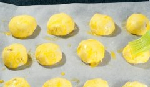 1. Этап. Творожники в духовке: На противень расстелите пекарскую бумагу. Выложите на неё творожники. Смажьте их сверху взбитым желтком.