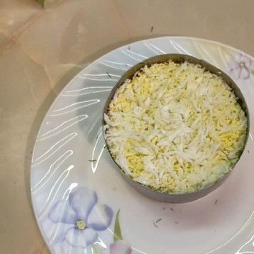 1. Этап. Салат Вкуснейший: Яйца натереть на мелкой тёрке и выложить на слой укропа.