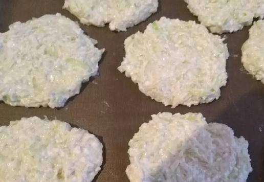 1. Этап. Оладьи кабачковые с творогом: Сыр натереть на мелкой тёрке и вмешать в массу. Выкладывать ложкой лепёшки на смазанный растительным маслом лист. Смазать необходимо, даже если у вас антипригарный коврик.