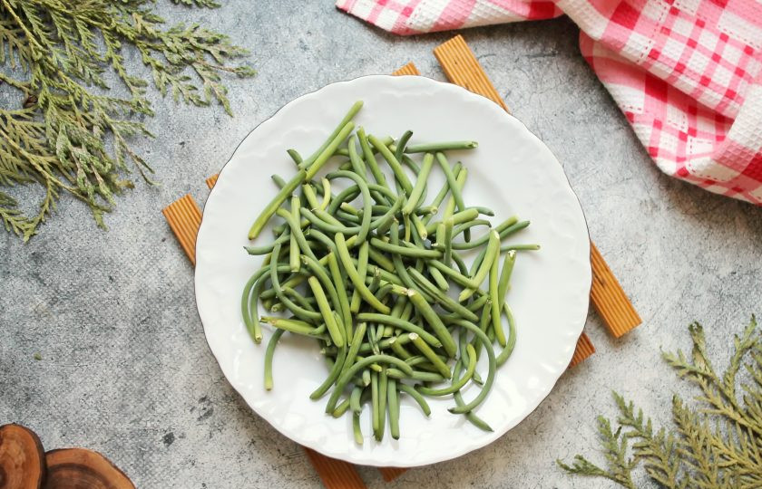 1. Этап. Чесночные стрелки по-корейски: Чесночные стрелки вымойте, удалите верхнюю часть с бульбочками и порежьте кусочками длиной 5-6 сантиметров.