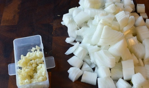 1. Этап. Рецепт вкусного мясного пирога: Лук и чеснок почистите и мелко нашинкуйте.