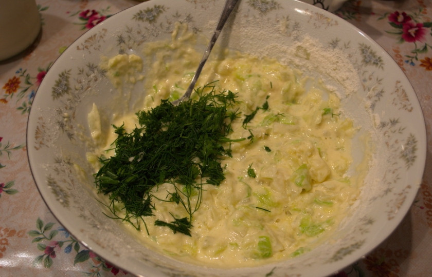 1. Этап. Капустные оладьи на кефире: Добавьте просеянную муку и зелень. Добавьте соль и перец по вкусу. Перемешайте. Тесто для оладьев готово.