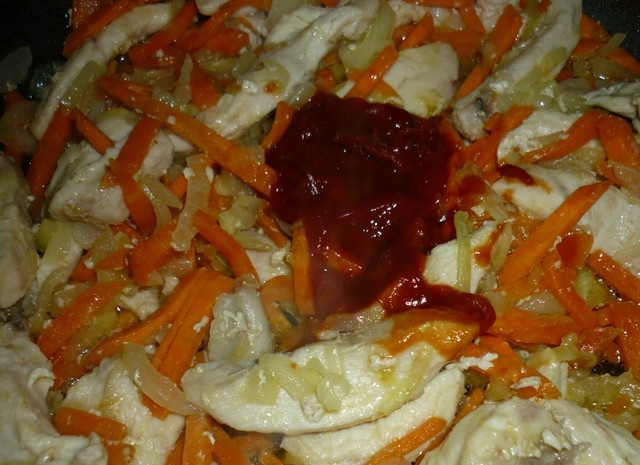 1. Этап. Гуляш из куриной грудки: Положите томатную пасту, перемешайте и тушите пару минут. Можете добавить столовую ложку воды по желанию.