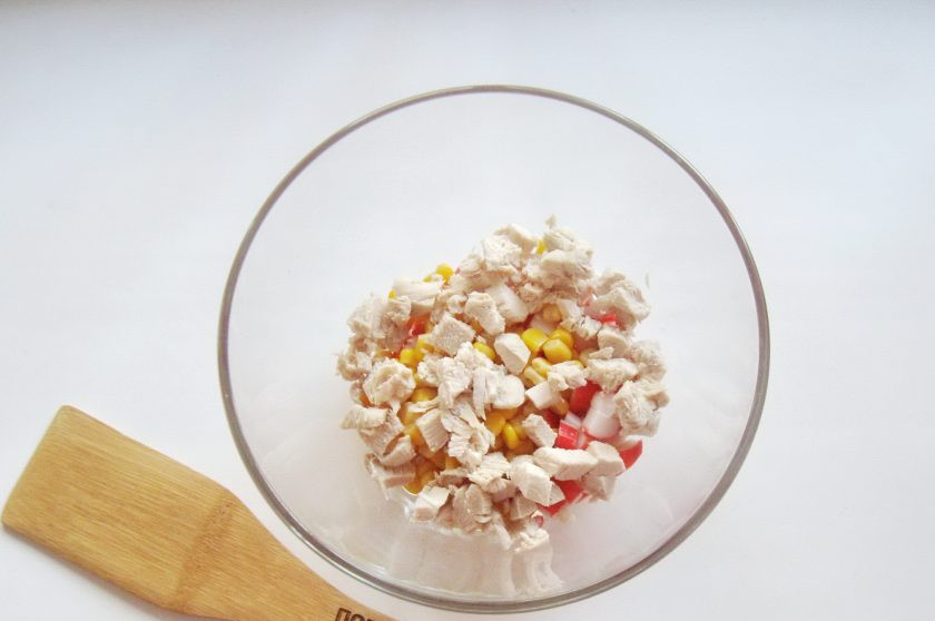 1. Этап. Салат Фантазия с крабовыми палочками: Куриную отварную грудку нарежьте мелко и добавьте в салат.