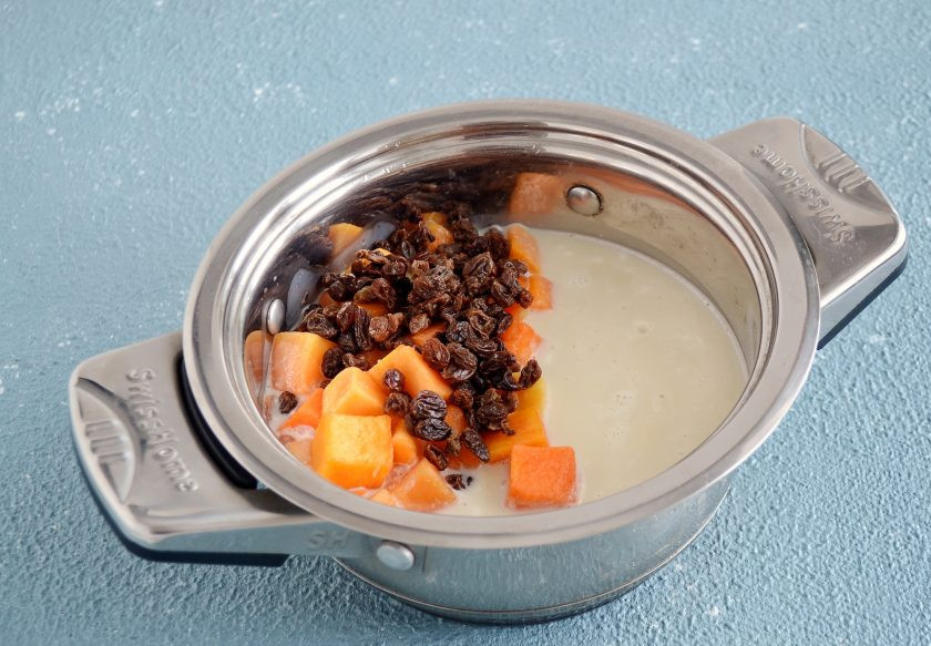 1. Этап. Рисовая каша с тыквой и изюмом: Добавьте в кастрюлю овсяное молоко, сахар, изюм и тыкву. Хорошо перемешайте. Продолжайте варить кашу 30 минут на средне-низкой температуре, пока тыква не станет мягкой.