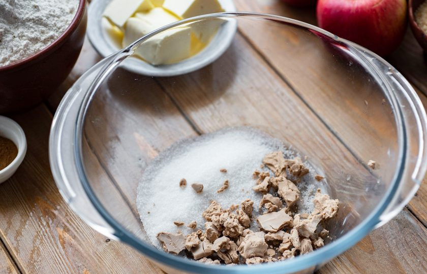 1. Этап. Булочки с яблоком и корицей из дрожжевого теста: Приготовьте опару. В миску разотрите пальцами свежие дрожжи, добавьте 1-2 ст.л. сахара.