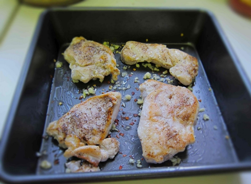 1. Этап. Макаронная запеканка с курицей: Обмазываем противень растительным маслом. Посыпаем измельченным чесноком и перцем чили. Обмазываем обжаренные куриные грудки растительным маслом и выкладываем их на противень.