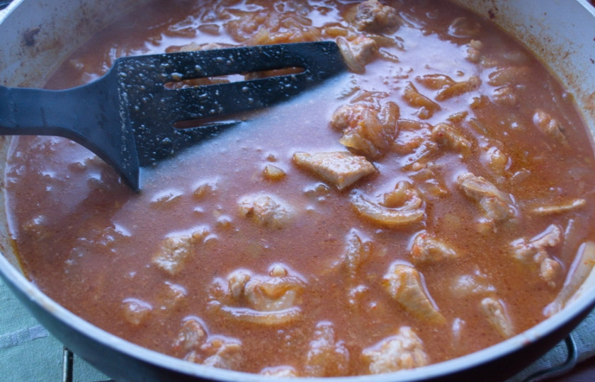 1. Этап. Гуляш из свиного окорока: Добавьте перетертые на терку томаты, без шкурки. Добавьте специи, соль. Тушите до готовности мяса. Можно подливать горячий бульон или кипяток по мере уваривания жидкости. В самом конце выдавите чеснок и добавьте его в гуляш.