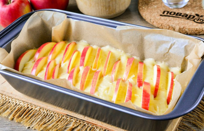 1. Этап. Ванильный кекс с яблоками: Форму для кекса выстелите бумагой для выпечки, влейте туда все тесто, а сверху выложите ломтики нарезанных яблок. Отправьте кекс в разогретую духовку.