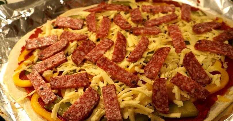 1. Этап. Творожная пицца: На тесто выложите все ингредиенты начинки. Я сперва выкладываю перец и огурцы, затем посыпаю тёртый сыр. Сверху выкладываю колбасу, чтобы она запеклась в духовке и выделила жир, который пропитает остальные ингредиенты.