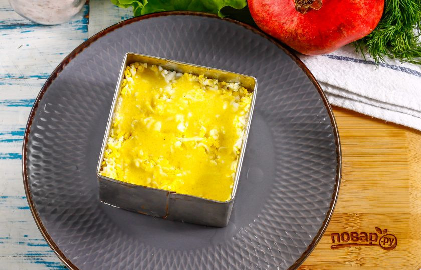 1. Этап. Салат Мужские слезы с гранатом: На терке с мелкими ячейками натрите куриные яйца и выложите натертую массу на слой лука. Присолите и смажьте майонезом.