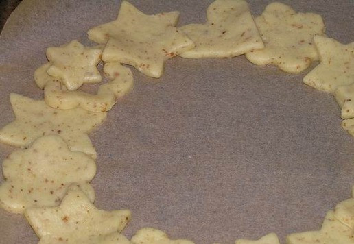 1. Этап. Миндальный рождественский венок: Разложите часть фигурок внахлест в виде кольца на противень, застеленный бумагой для выпечки.