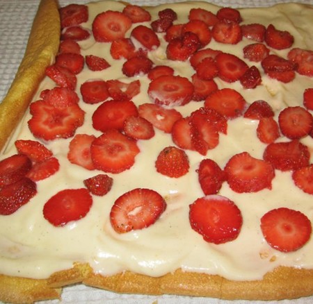 1. Stage. Strawberry roll: For cream, whip the cream with powdered sugar, and cut the strawberries into thin slices. Expand the roll, grease with cream and spread the strawberries.