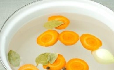 1. Этап. Суп из шампиньонов постный: Очищенную луковицу и порезанную пятаками морковь положите в кастрюлю и залейте холодной водой. Добавьте лавровый лист, перец горошком и варите полчаса.