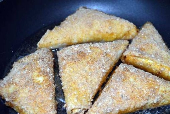 1. Этап. Треугольники из лаваша с сыром: Взбейте яйцо с молоком, обмакните в него треугольник из лаваша. Теперь можно отправлять его на сковороду и обжаривать. А можно после того, как обмакнули в яйцо, обвалять треугольники в сухарях, а уже потом обжаривать. Выбирайте свой вариант.