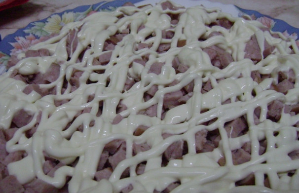 1. Этап. Салат с хреном: 3. Приступайте к формированию блюда. Отожмите хрен от маринада и уложите на дно тарелки тонким слоем. Сверху положите слой нарезанной мелко колбасы. Покройте майонезом. Далее уложите слоями потертые на крупной терке овощи в такой последовательности: морковь, картофель, майонез, порезанная зелень.