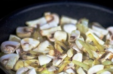 1. Этап. Мясо, тушенное в духовке: К луку добавляем очищенные и нарезанные шампиньоны. Обжариваем их до тех пор, пока не выпарится жидкость и грибы не станут золотистого цвета.