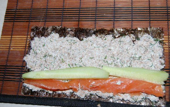 1. Этап. Диетические роллы: Выкладываем огурец и семгу. Край нори смочите водой.