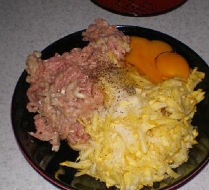 1. Этап. Куриные мешочки с кабачком: 2. От костей отделить мясо и пропустить его через мясорубку. Кабачок вымыть. Если кабачок большой, снимите с него кожицу. Если молодой, то используйте его целиком. Кабачок и зубчики чеснока натереть на мелкой терке. В отдельной посуде смешать куриный фарш, тертые кабачок и чеснок, яйца. Все перемешать до однородной массы, посолить и поперчить.