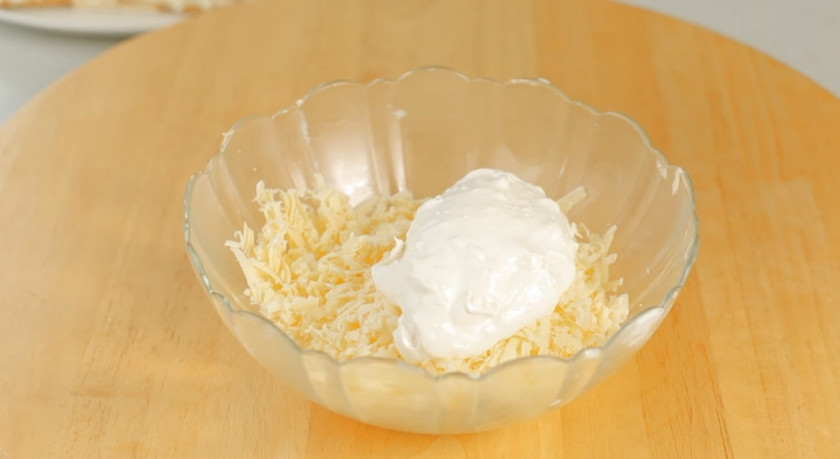 1. Этап. Лучший закусочный торт из крекеров и рыбной консервы: 8. Для третьего слоя натрите на крупной терке сыр, добавьте две столовые ложки заправки и перемешайте.