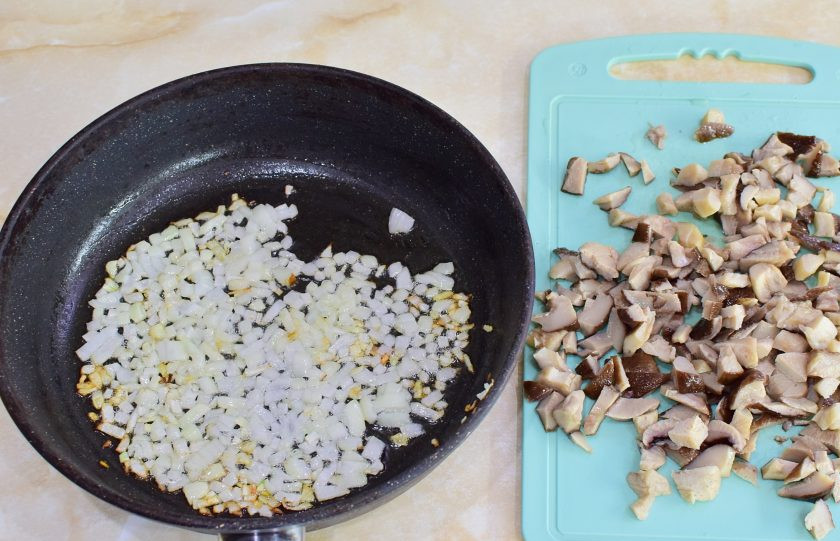 1. Этап. Жареные пирожки на кефире с картошкой и грибами: Для приготовления начинки мелко нарежьте лук и обжарьте его до золотистого цвета. Затем добавьте к нему грибы. Перемешайте и обжарьте грибы с луком 3-5 минут. По вкусу подсыпьте немного соли и специи.