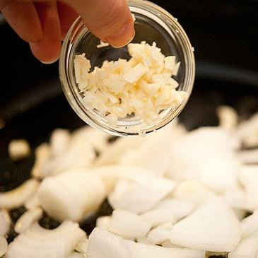 1. Этап. Яичница с капустой кале и сыром Фета: 2. В сотейнике на среднем огне нагреть оливковое масло. Обжарить лук и чеснок в течение 3-5 минут, пока они не станут мягкими.