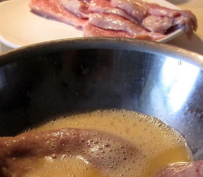 1. Этап. Телятина по-милански: Обмакните кусок телятины в яйце.