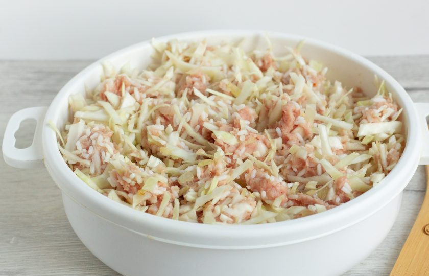 1. Этап. Запеканка А-ля голубцы: Также добавьте фарш и рис. Всё хорошо перемешайте. Посолите и поперчите по вкусу.