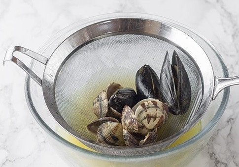 1. Этап. Рис с морепродуктами: Перекладываем на дуршлаг. Жидкость, которая слилась, добавляем в бульон из креветочных панцирей и овощей. Достаем мидии из ракушек, несколько ракушек оставим для сервировки, остальные нам не нужны.