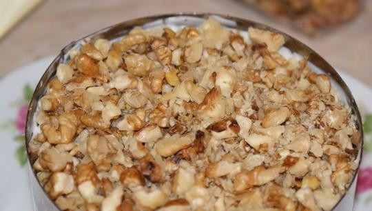 1. Этап. Салат Гранатовый браслет с сыром: Следующим слоем выложите измельчённые орехи. Немного смажьте их майонезом.