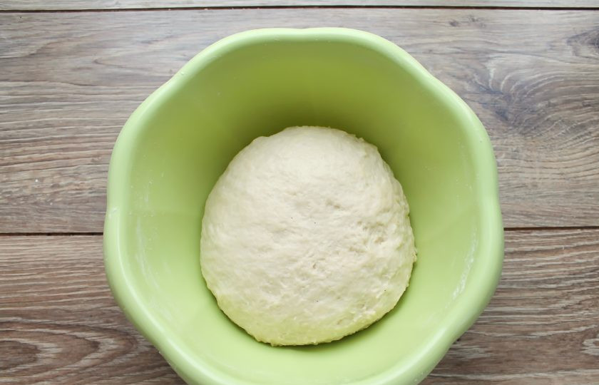 1. Этап. Тесто на живых дрожжах: Часть муки смешайте с разрыхлителем и добавьте в миску с жидкостью, перемешайте. Постепенно добавляя муку, замесите мягкое, не липкое тесто.