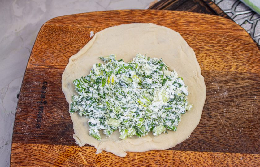 1. Этап. Чуду с черемшой: Кусочек теста раскатайте в тонкую лепешку. На середину выложите немного начинки.