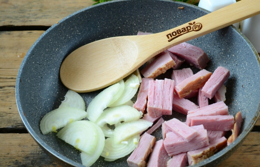 1. Этап. Жаркое по-уральски (рецепт из сказки!): Лук порежьте полукольцами, копченую грудинку нарежьте брусочками. Выложите все в сковороду с разогретым маслом и жарьте до обретения луком золотистого цвета.