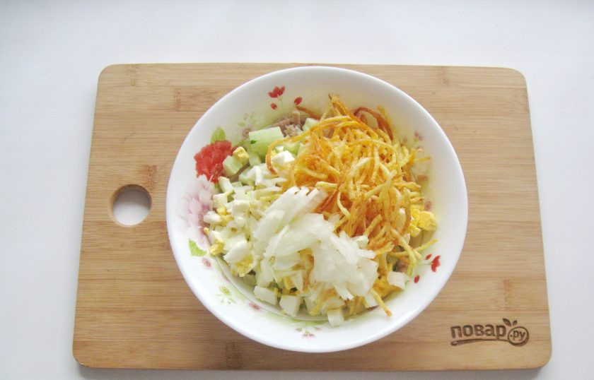 1. Этап. Салат Воронье гнездо: Репчатый лук очистите, помойте и нарежьте произвольно. Добавьте в салат. Если лук очень горький, то можно его обдать кипятком.