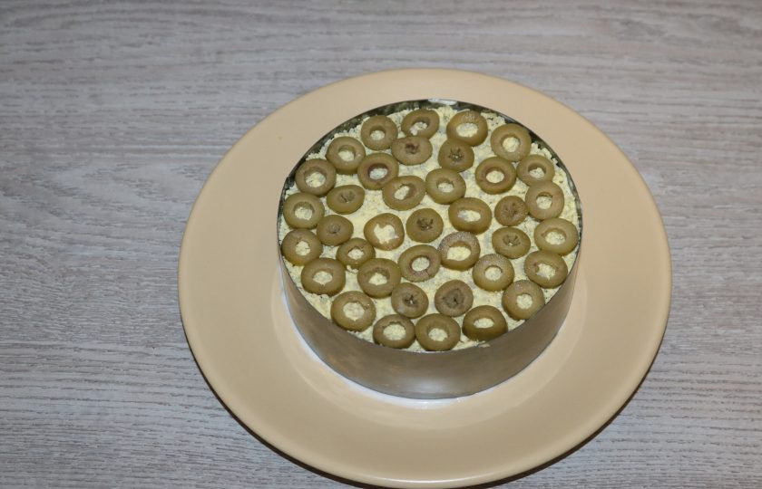 1. Этап. Слоёный салат с жаренными шампиньонами: Оливки нарежьте колечками, выложите на верх салата.