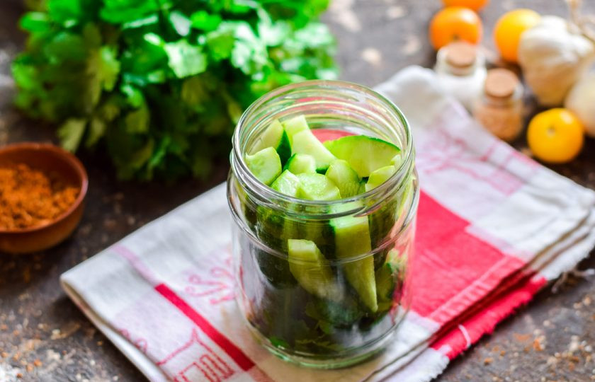 1. Этап. Пьяные огурцы: Банки для заготовки вымойте и простерилизуйте удобным способом. Наполните банки огурцами, на дно выложите чистую зелень, горошины перца и чеснок.