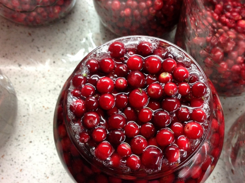 1. Этап. Компот из брусники на зиму: Снимаем кастрюлю с огня и заливаем сиропом ягоды так, чтобы жидкость полностью занимала банку и даже переливалась через верх.