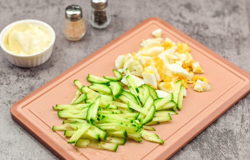 1. Этап. Салат Марианна: Свежий огурец ополосните и просушите, после нарежьте огурец небольшими полосками. Куриное яйцо сварите вкрутую — 10-12 минут. После яйцо остудите и почистите, нарежьте небольшими кубиками.