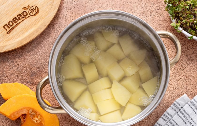 1. Этап. Пюре из тыквы и картофеля на кокосовых сливках: Картофель очистите от кожуры, нарежьте ломтиками и переложите в кастрюлю. Влейте воду, доведите до кипения и готовьте до мягкости около 20 минут.