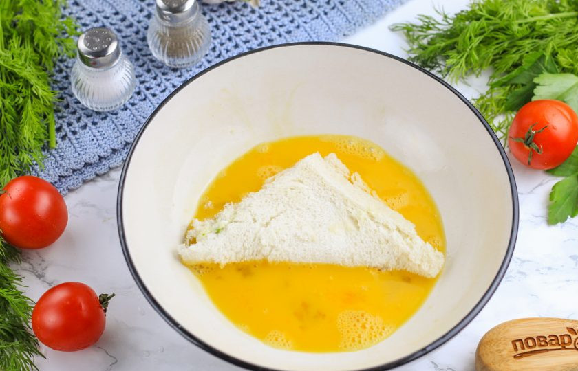 1. Этап. Пирожки из тостового хлеба: Прогрейте сковороду с растительным маслом на плите и уменьшите нагрев до минимального. Обмакните заготовки во взбитые яйца и выложите на сковороду.