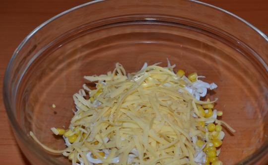 1. Этап. Салат Новогодний фейерверк: 3. В салатник выложите кальмары, добавьте кукурузу. Натрите на терке немного сыра.