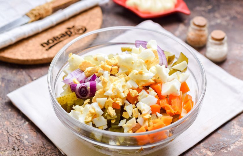 1. Этап. Мясной салат на Новый год: Куриные яйца отварите 10 минут, почистите и нарежьте кубиками, добавьте в салат.