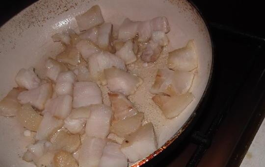 1. Этап. Капустняк украинский: Нарежьте шпик кубиками. Обжарьте его до состояния шкварок в сковороде. Посолите.