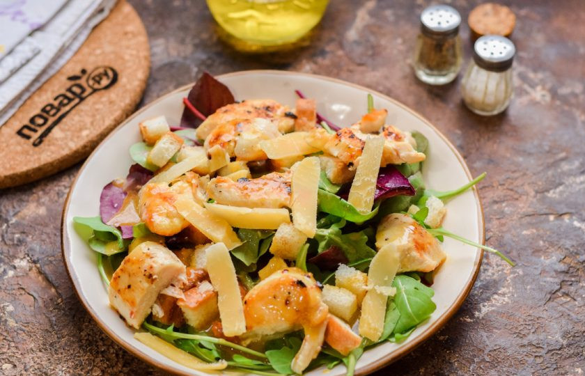 1. Этап. Салат Цезарь от Гордона Рамзи: Полейте салат остатками соуса и добавьте сыр, нарезанный тонкими пластинами.