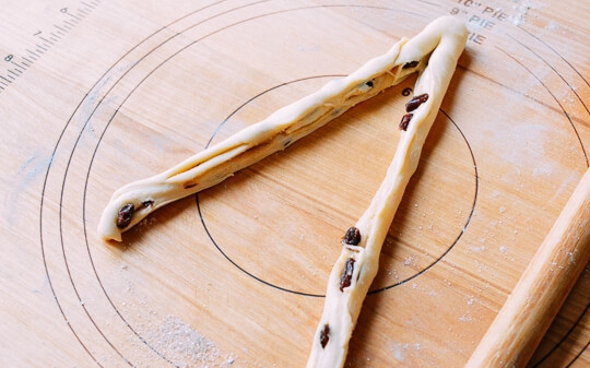 1. Этап. Булочки Розы с изюмом: 3. Острым ножом разрежьте рулетик вдоль на 2 части, не дорезайте с одного края.