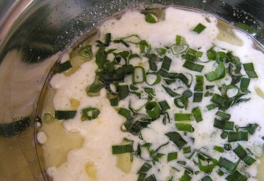 1. Этап. Пирог с лососем, зеленью и овощами: Добавьте нарезанный зеленый лук, соль и перец, перемешайте.