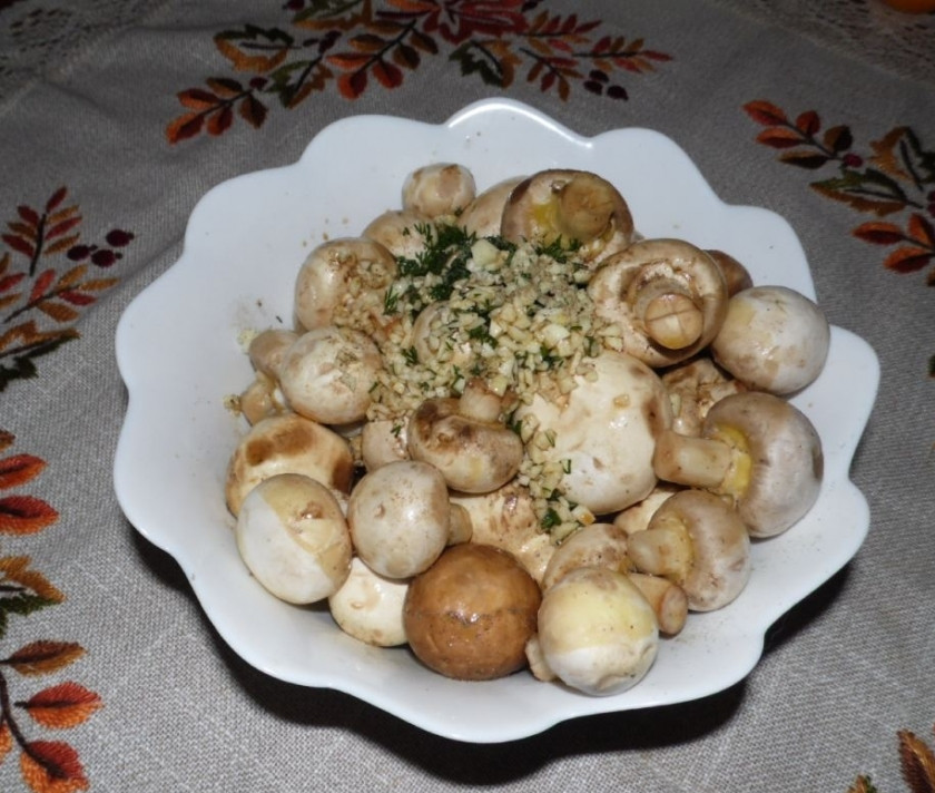 1. Этап. Шампиньоны на шампурах: Шампиньоны хорошо промойте и очистите. Нарезать их не нужно, они будет запекаться целиком. Поэтому выбирайте не слишком большие грибы. Положите грибы в тарелку и присыпьте их укропом с чесноком.